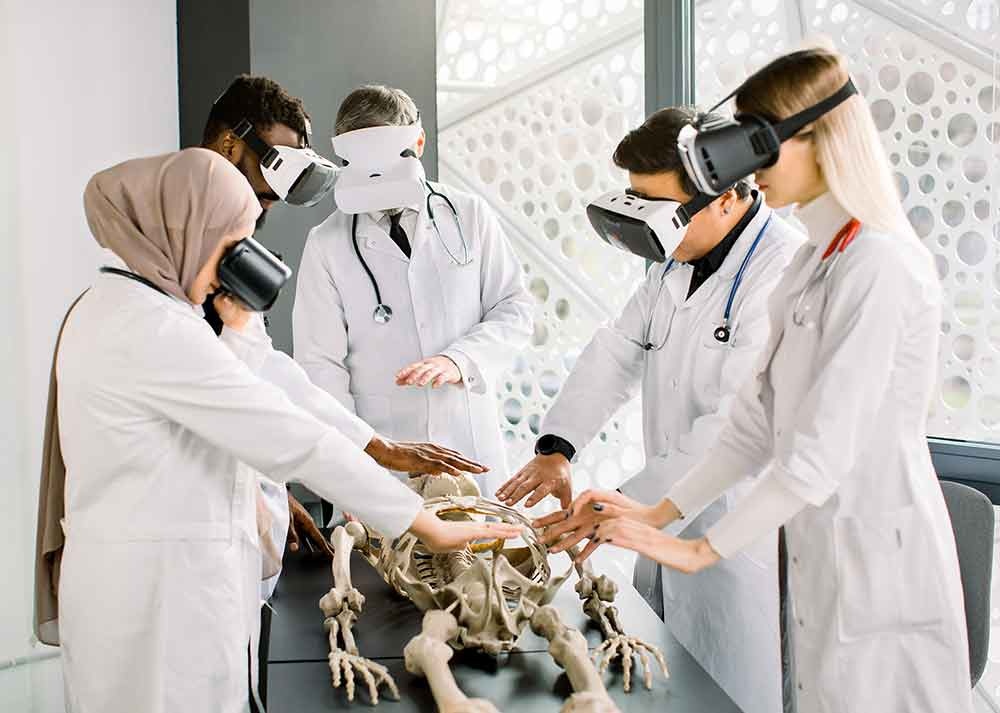 Medical skill development: team of medical students examining bones, studying human skeleton anatomy using virtual reality glasses